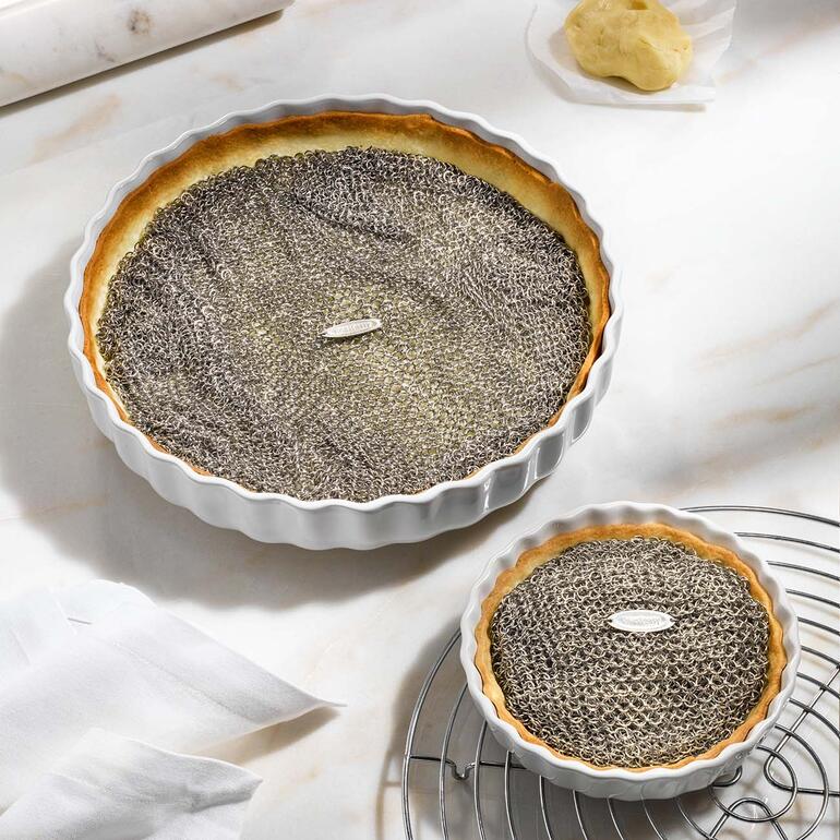 Deux tartes avec une couverture en filet sur une étagère de refroidissement.