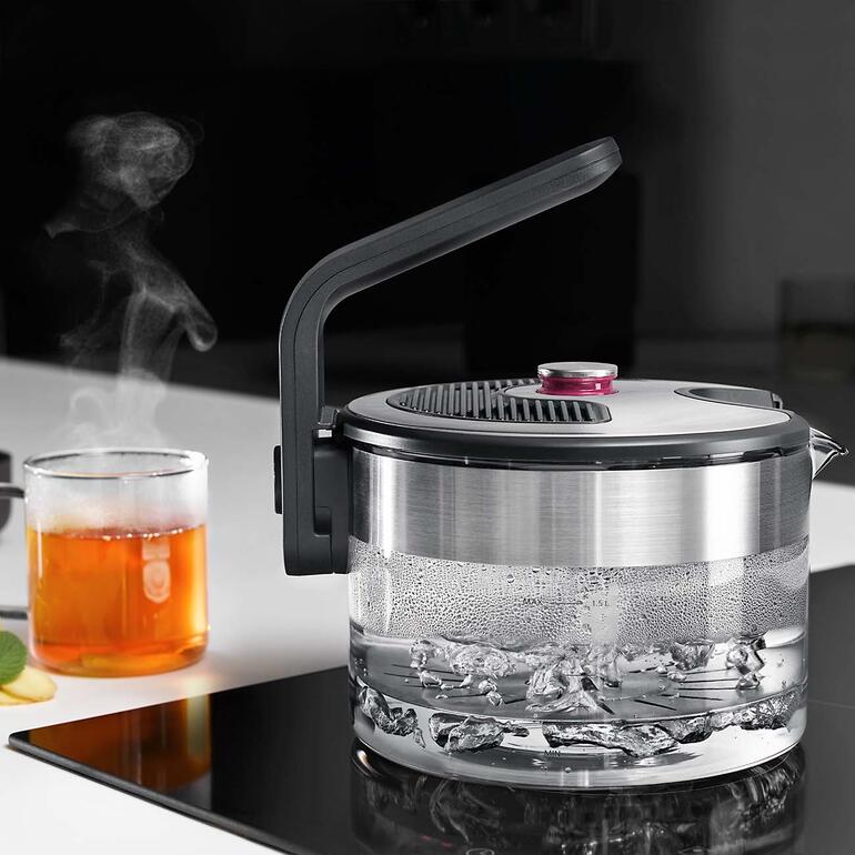 Bouilloire à induction avec de la vapeur sur la cuisinière.