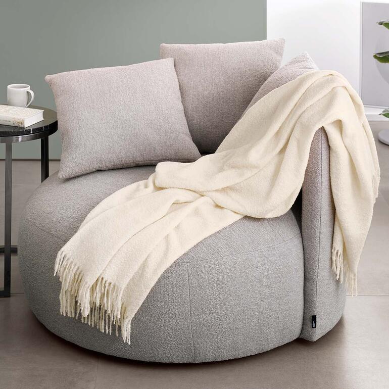 Couverture en bouclé d'alpaga sur un fauteuil rembourré.