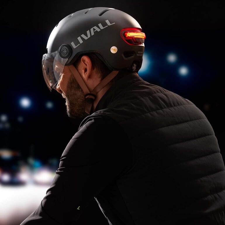 Homme portant un casque Livall L23 de vélo électrique, regardant à gauche.
