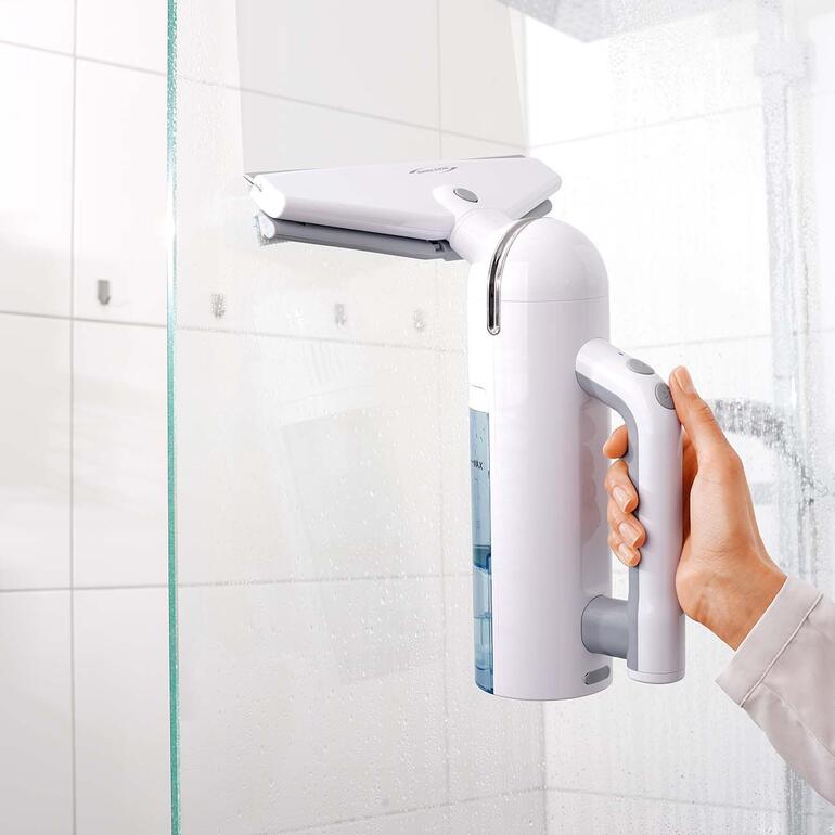 Idéal également pour les miroirs, le pare-brise, le carrelage, la cabine de douche, la véranda … Main tenant un nettoyeur de fenêtres sans fil blanc dans une salle de bain.