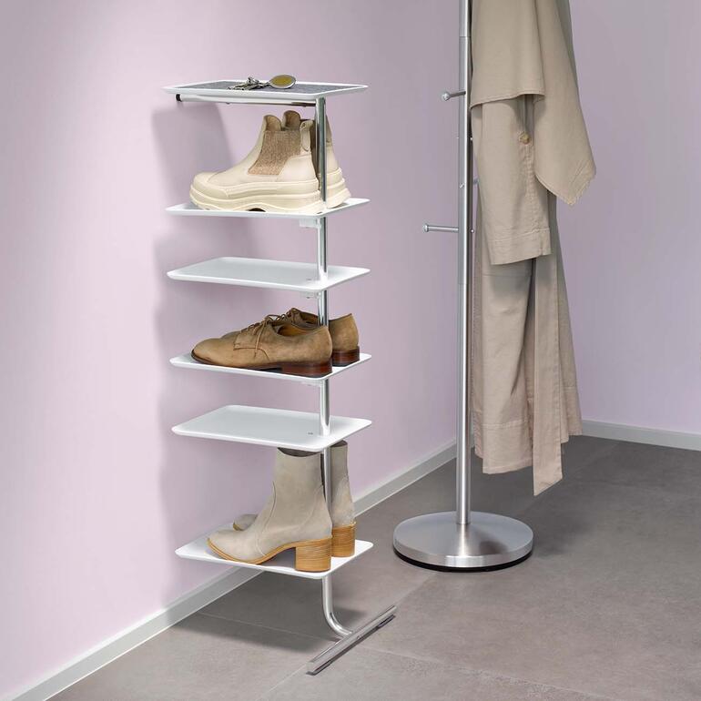 Étagère adossée avec des chaussures et un manteau dans le couloir.