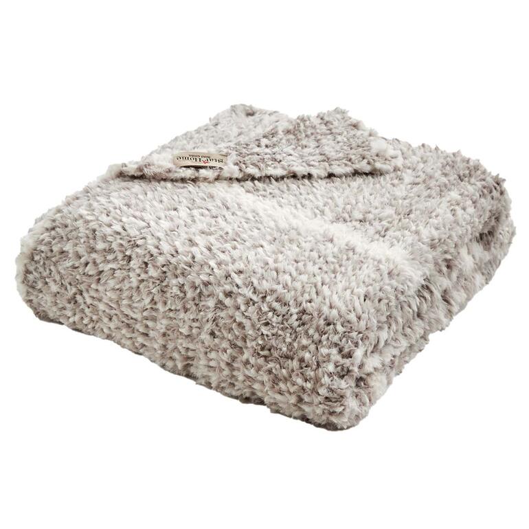Le haut et le bas de la couverture présentent un motif tricoté autant esthétique que douillet. Couverture en fausse fourrure pliée sur fond blanc.
