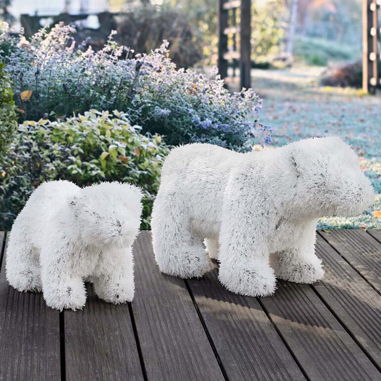 Deux ours polaires en peluche en matière synthétique sur un tapis en bois.