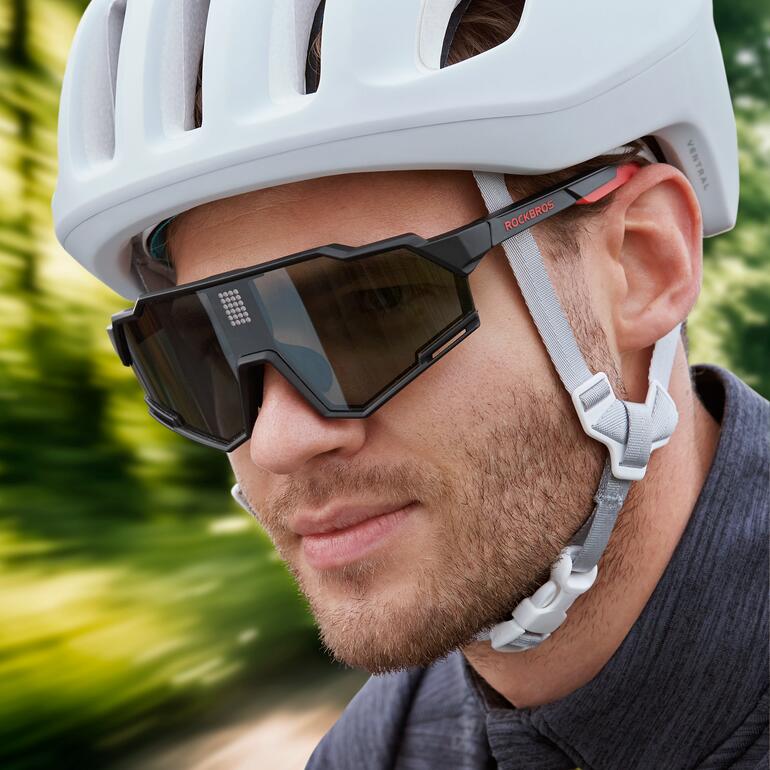 Homme portant des lunettes de soleil LCD photochromiques sous un casque de vélo.