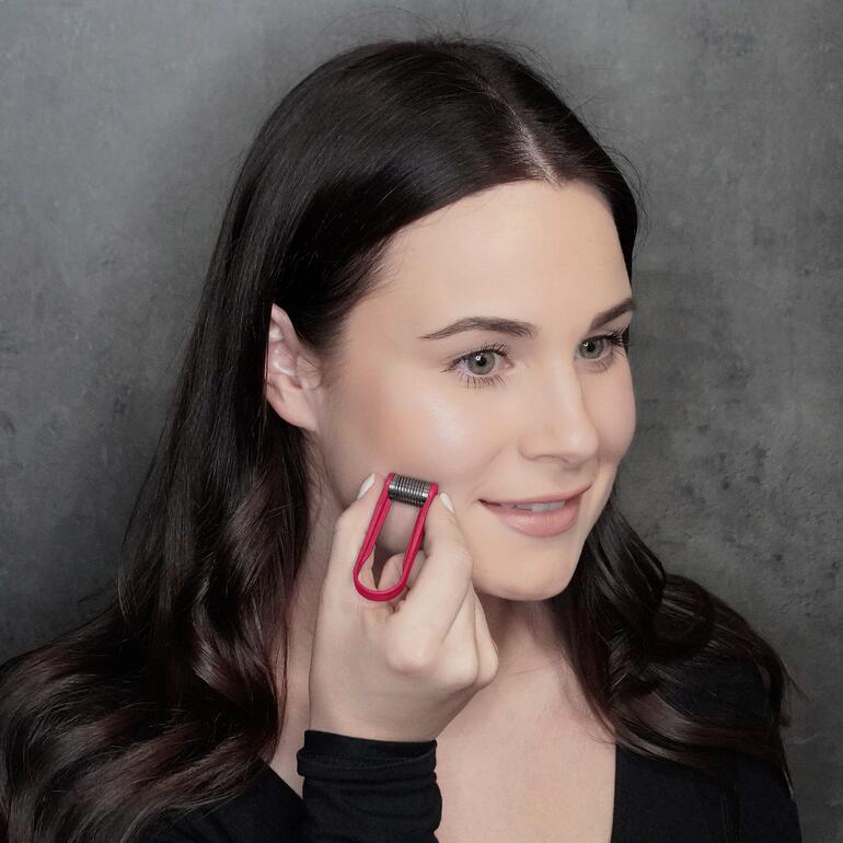 Femme utilisant une pince épilatoire pour épiler le visage.