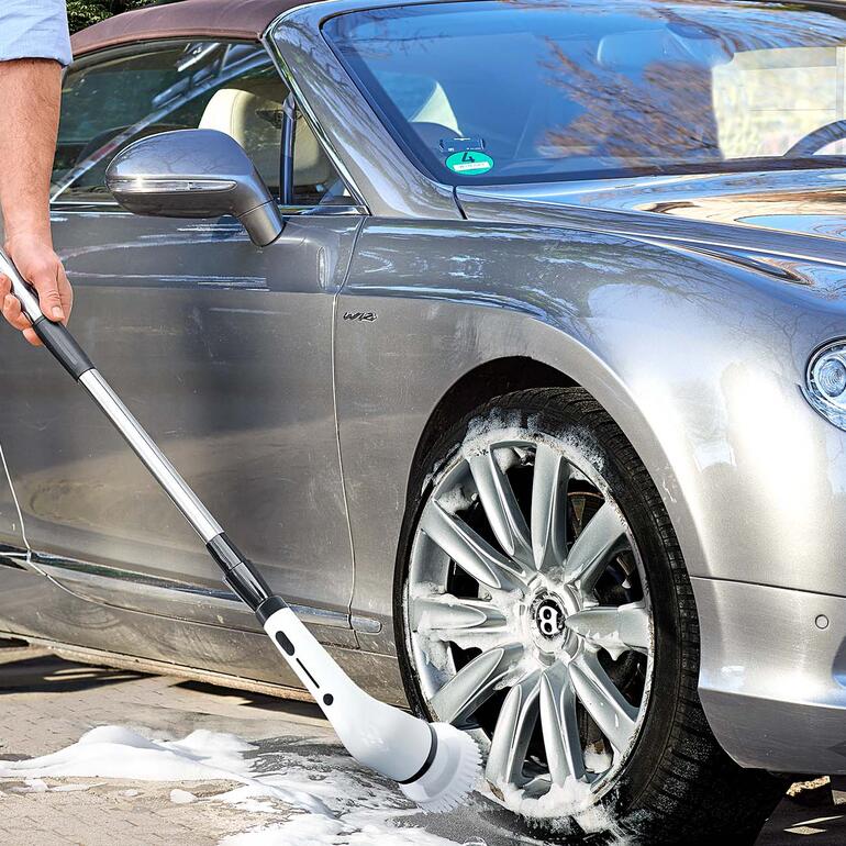 Homme nettoyant la voiture avec une brosse de nettoyage électrique