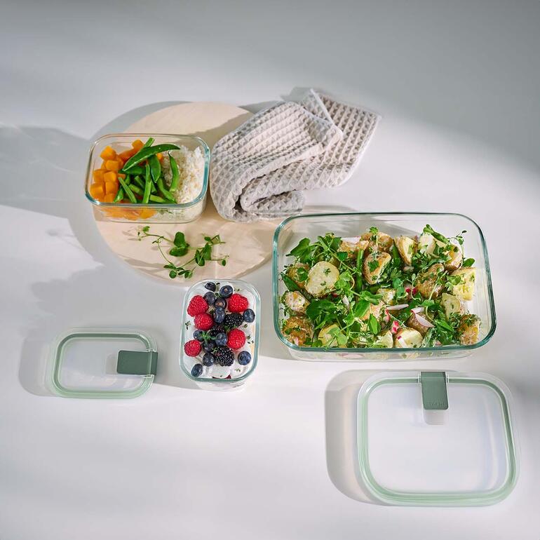 Idéal également pour cuire, faire gratiner, servir ... Différentes boîtes hermétiques en verre contenant des aliments sur une table.