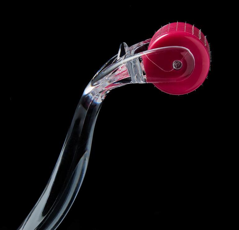 192 pointes ultrafines, posées à la main, en acier chirurgical et au revêtement en argent pénètrent dans la couche supérieure rugueuse de la peau et éliminent les cellules mortes. Gros plan du Beautyroller® 2.0 avec un rouleau rose.