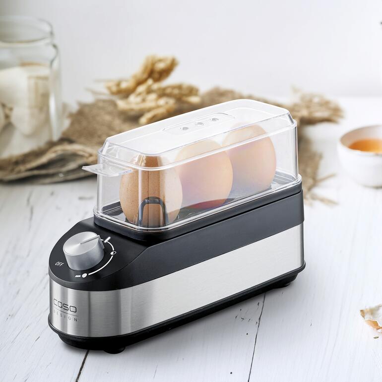 Cuit-oeufs au design compact avec couvercle transparent et trois œufs.