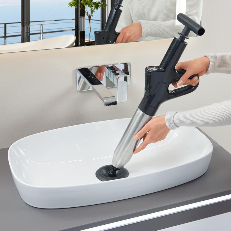 Personne utilisant un déboucheur de 6 bars dans un évier