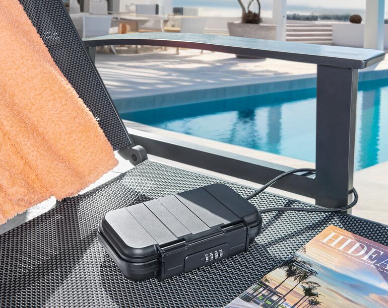 Coffre mobile sur une chaise longue au bord de la piscine
