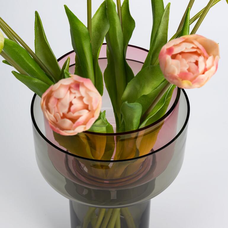 Vase en verre Vario avec des tulipes et un feuillage vert, au centre de l'image.