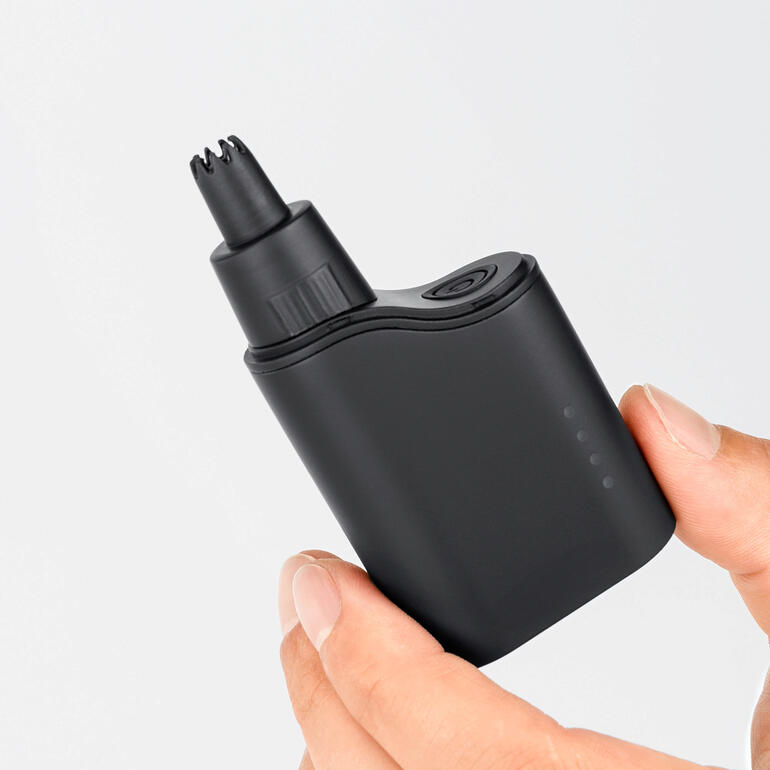 Tondeuse à cheveux pour nez/oreilles 2-en-1 dans la main, forme compacte et pratique.