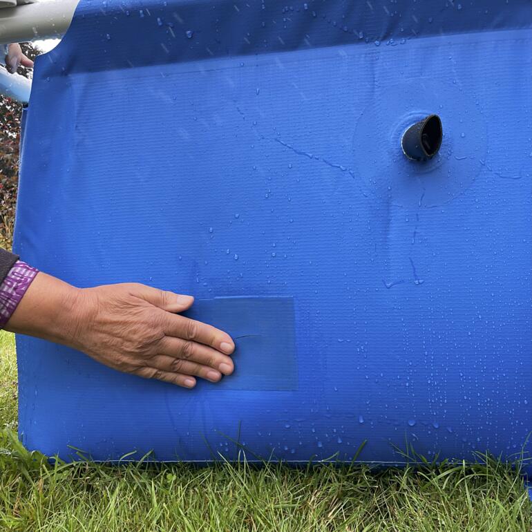 Personne collant du ruban adhésif sous l'eau sur un matériau de piscine bleu.
