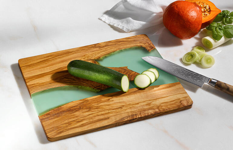Planche à découper River-Design avec surface verte et une tranche de concombre dessus