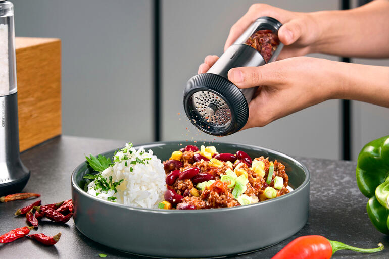 Trancheur à piments X-Plosion® Le coupe-chili X-Plosion® est tenu au-dessus d'une assiette de riz et de légumes