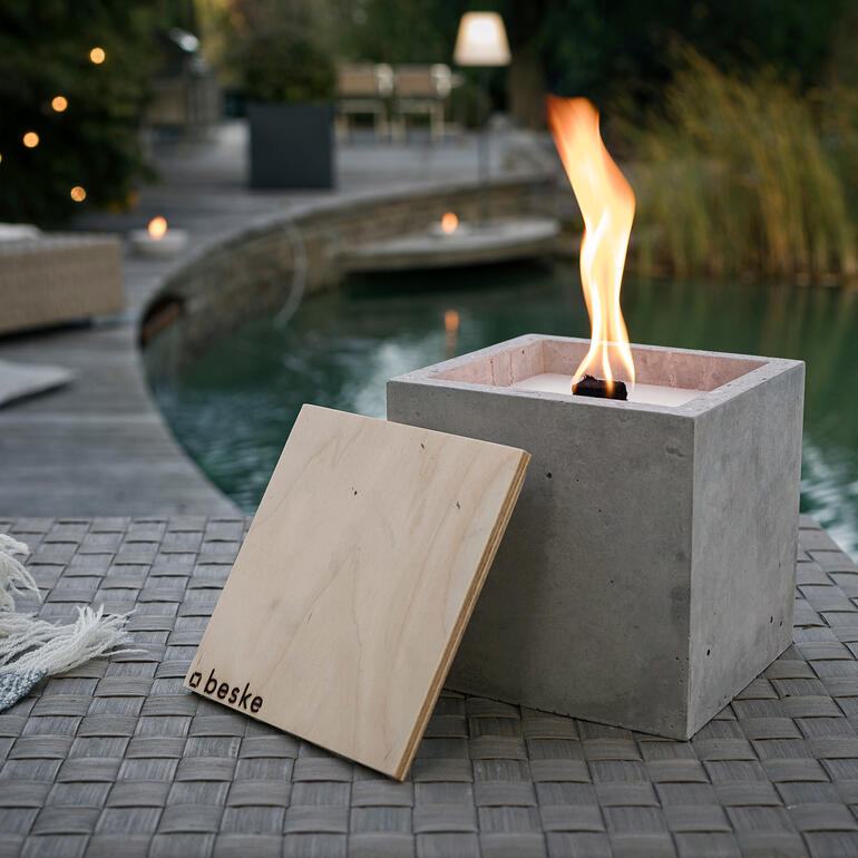 Bougie en béton faite à la main sur une table près de l'eau.