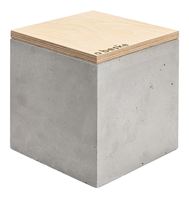 Le cube de béton, remplissage de cire et couvercle dʼextinction inclus, avec le sceau original Beske. Bougie en béton faite à la main avec un couvercle en bois sur fond clair.