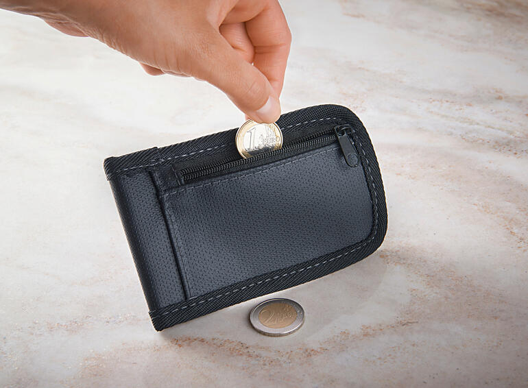 Étui à clé RFID sécurisé Étui à clés RFID avec une main mettant une pièce dans le compartiment.