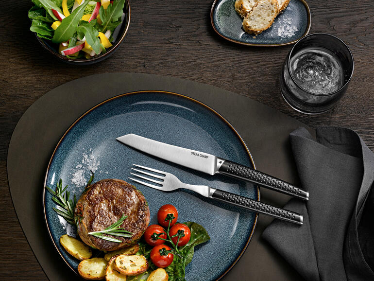 Couverts à steak Prime Rib, ensemble de 2 sur une assiette moderne avec du steak et des accompagnements.