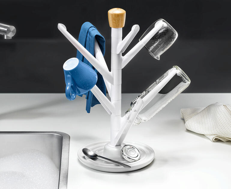 Égouttoir à 7 bras avec des tasses et de la vaisselle sur une table