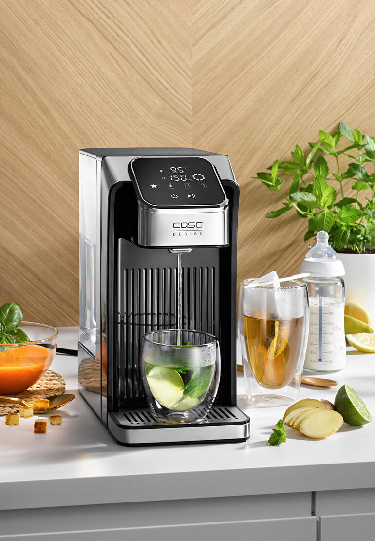 Distributeur d'eau chaude Turbo avec des verres et des ingrédients frais sur la table.