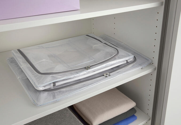 Boîte de rangement pliable, repliée sur une étagère.
