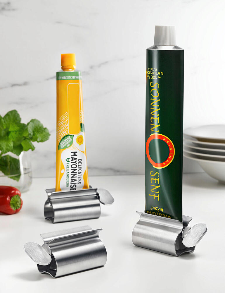 Presse-tube en acier inoxydable avec poignée XXL tenant deux tubes dans la cuisine.