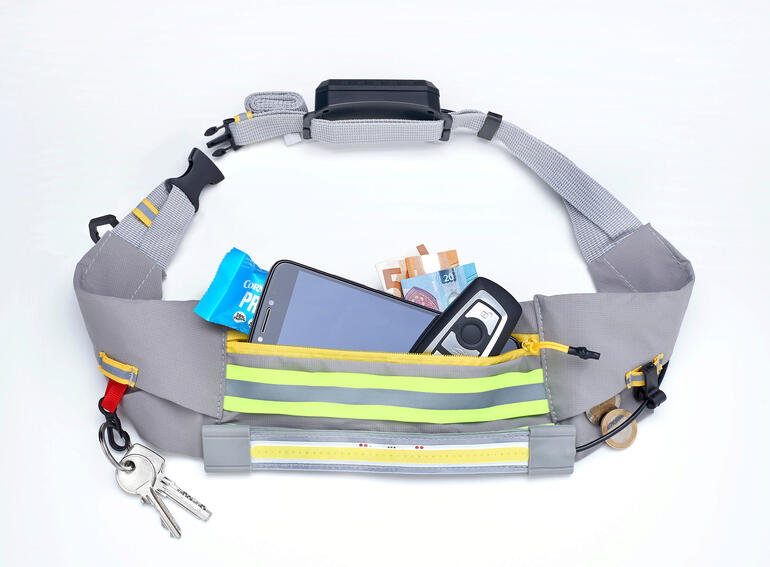 Ceinture LED avec smartphone et billets dans le compartiment principal.