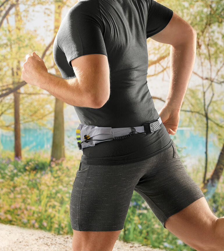 Idéal pour ceux qui joggent, marchent, font du vélo ou du ski. Rien ne claque ni ne glisse. Coureur portant une ceinture LED dans un environnement forestier lumineux.