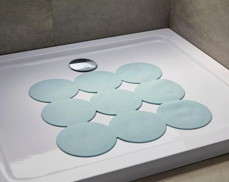 Tapis antidérapant dans une douche avec des contours clairs.