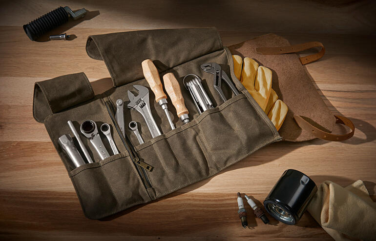 Trousse à outils en cuir véritable avec divers outils sur une surface en bois