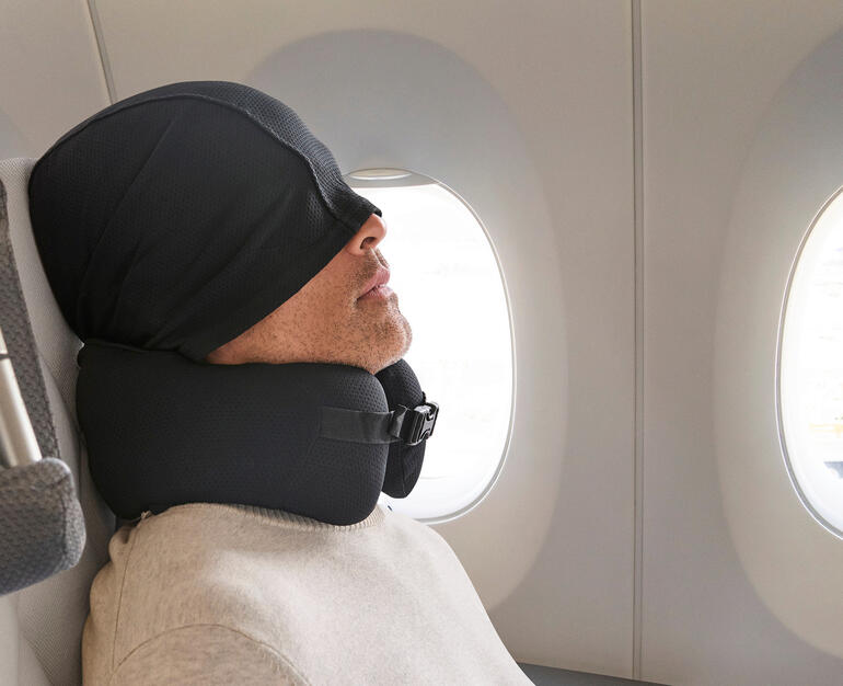 Oreiller cervical confort avec capuche Homme avec un coussin de voyage confortable et une capuche dans un avion