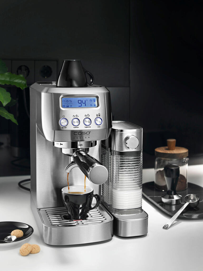 Machine à espresso avec écran numérique et tasse sur un plan de travail.