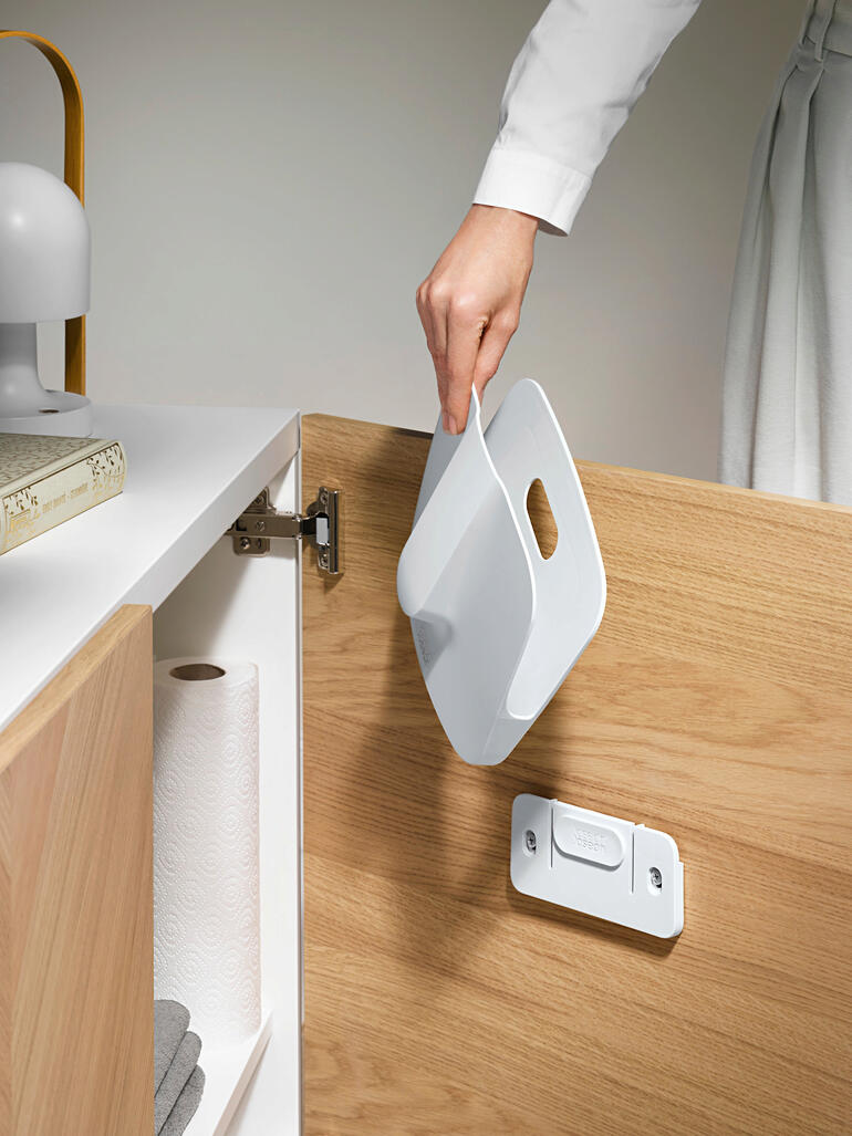 Les miettes et poussières, qui étaient éventuellement restées collées après utilisation, tombent dans le support amovible et peuvent être proprement mises à la poubelle. Main tenant une pelle dans un placard pour un rangement pratique.
