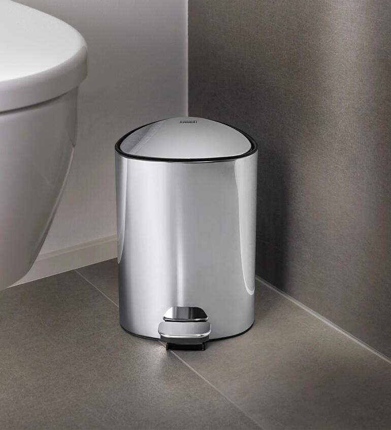 Poubelle de salle de bain ronde avec pédale dans une salle de bain moderne.