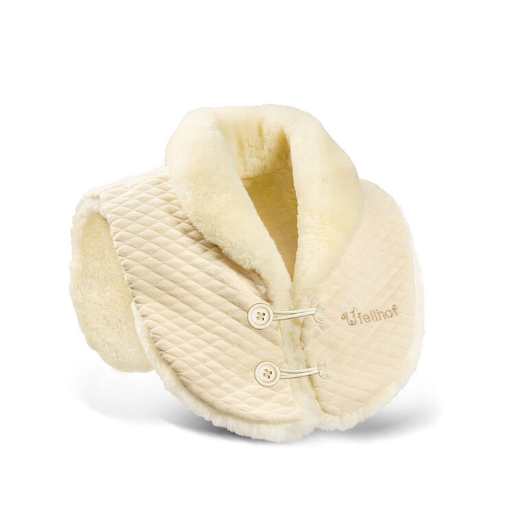 Le chauffe-épaules est recouvert à lʼxtérieur de jersey de coton matelassé avec deux boucles – la douce peau dʼagneau à lʼintérieur diffuse une agréable chaleur. Chauffe-épaule en peau d'agneau beige en vue de côté sur une table