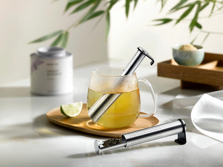 Filtre à thé long aromatique dans une tasse de thé avec du citron vert