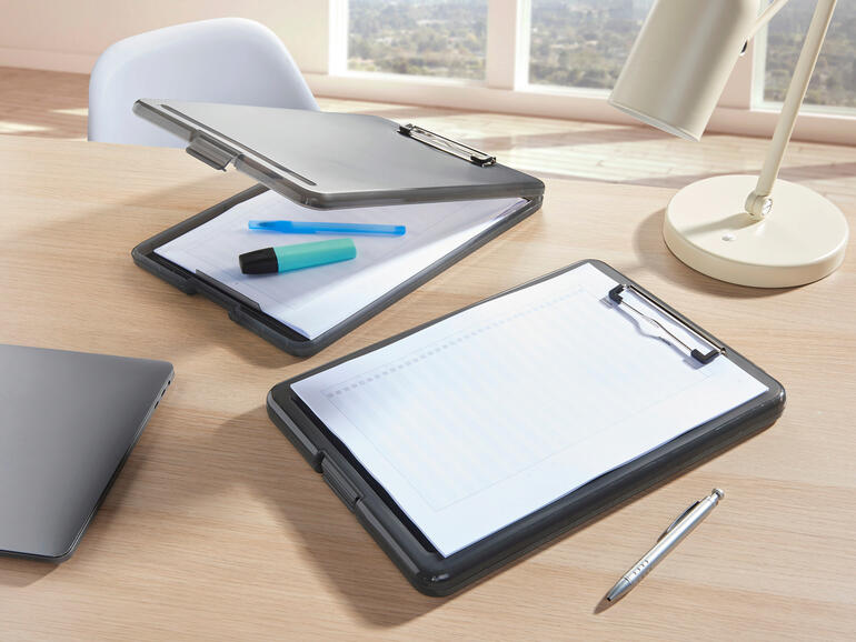Deux classeurs transparents sur un bureau avec des stylos et un ordinateur portable.