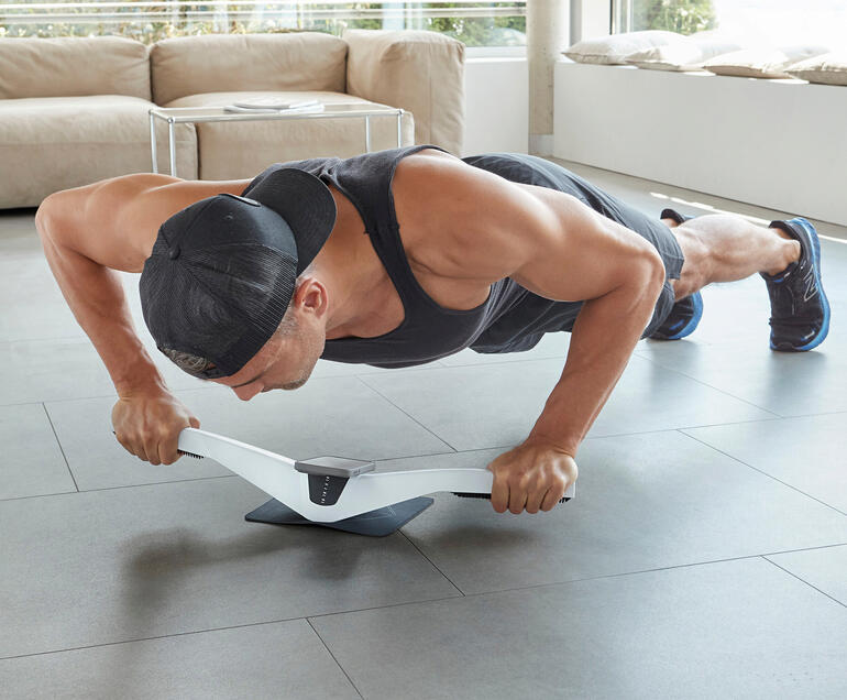 Homme réalisant un exercice de planche avec le trainer Praep® sur le sol.