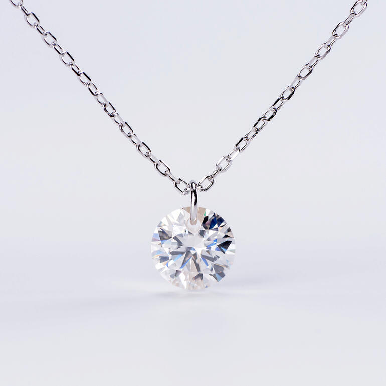 Également disponible avec une chaîne rhodiée. Gros plan d'un pendentif en moissanite flottant avec chaîne rodiée.
