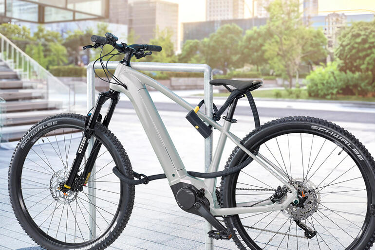 Antivol en U avec câble de sécurité monté sur un vélo.