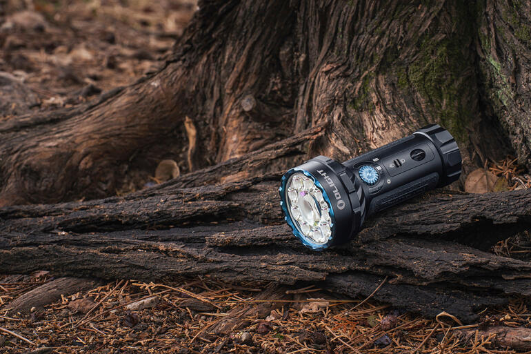Lampe de poche compacte sur une souche dans la forêt.