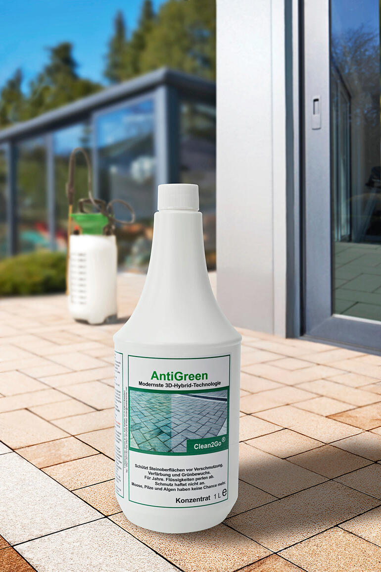 Bouteille AntiGreen, 1 litre de concentré sur un sol pavé