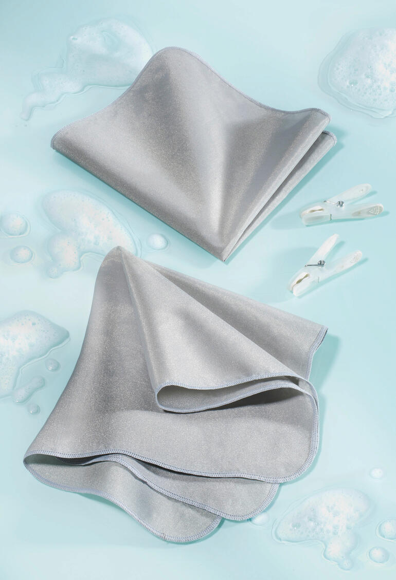 Chiffon SilverWash® pour machine à laver en gris sur fond aquatique bleu