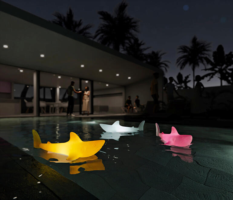 Luminaires en forme de requin colorés flottant dans la piscine la nuit