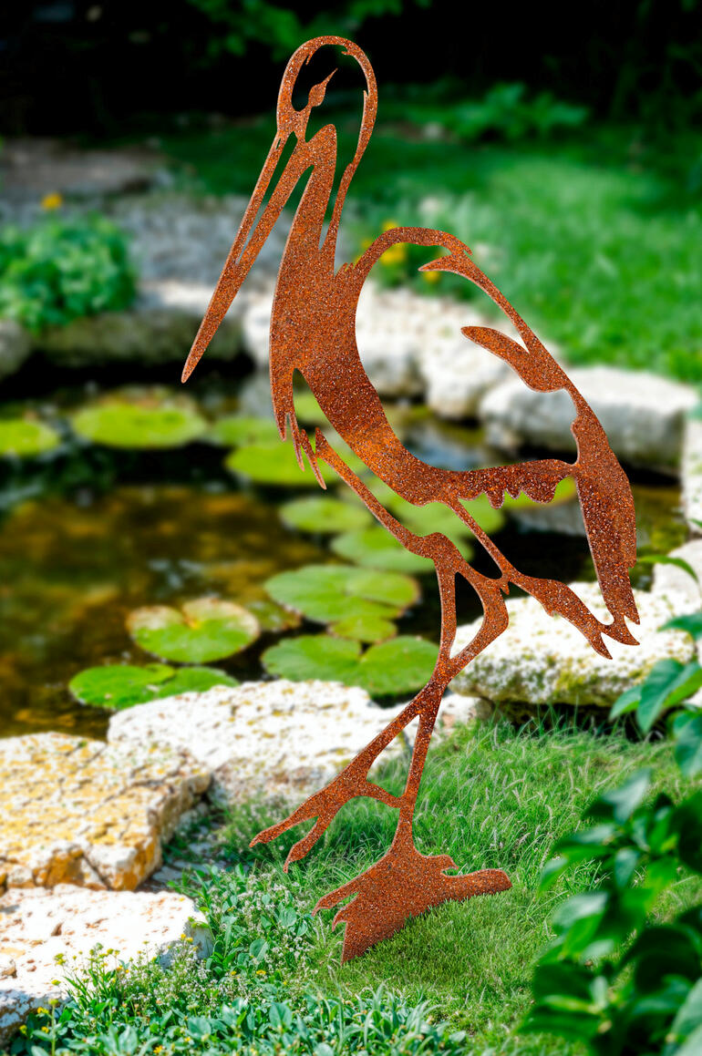 Piquet de jardin en forme de héron de couleur rouillée dans le jardin