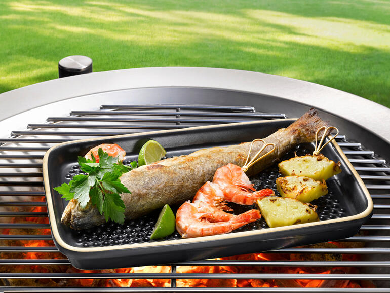 Poisson et crevettes sur une plaque de cuisson à l'extérieur