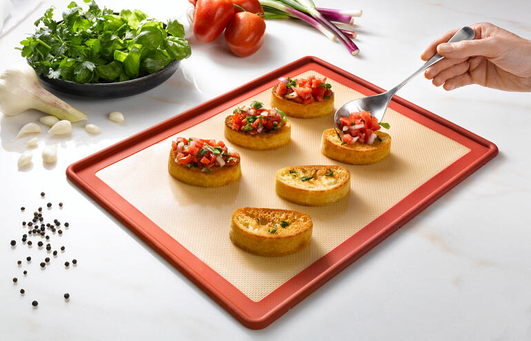 Tapis de cuisson NoStik avec des tartines garnies sur un plan de travail